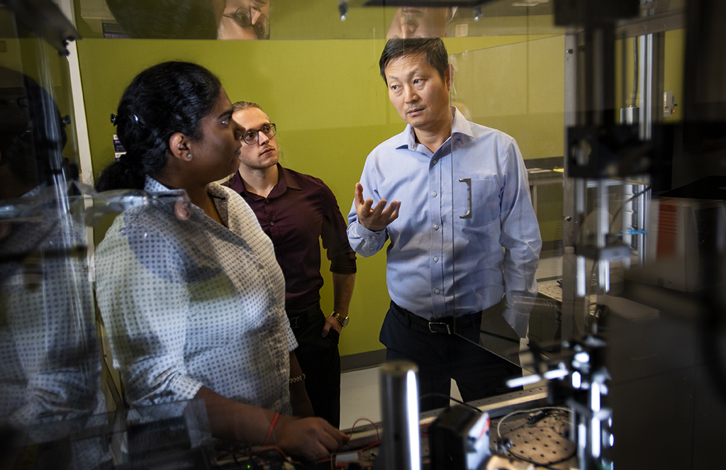 Tae-Youl Choi talks with students in a lab.