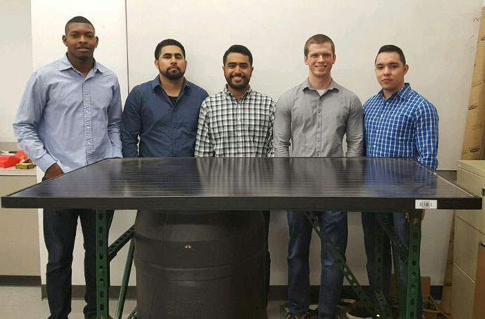 The team poses with solar panel system
