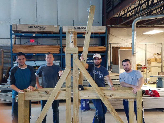 Team members with the wooden trebuchet