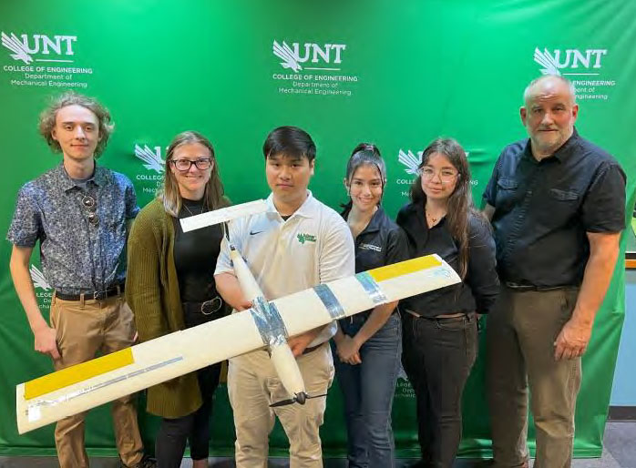 Photo of team members with the printed airplane