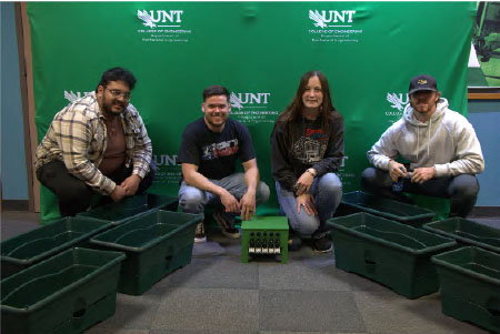 Team members pose with the system and garden boxes