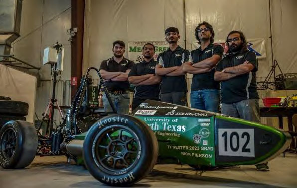 Team members pose with the racecar