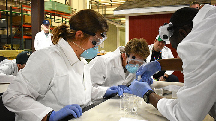 High school students in lab coat and gloves