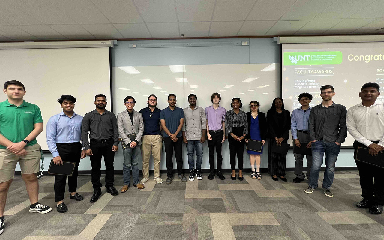 Students posing in front of projector screen