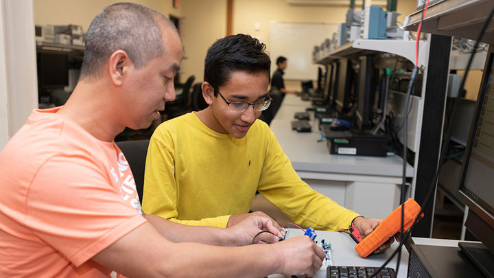 Students testing electric circuit using a meter in Dr. Acevedo's lab