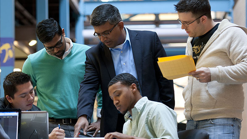 A professor discussing course work with four students