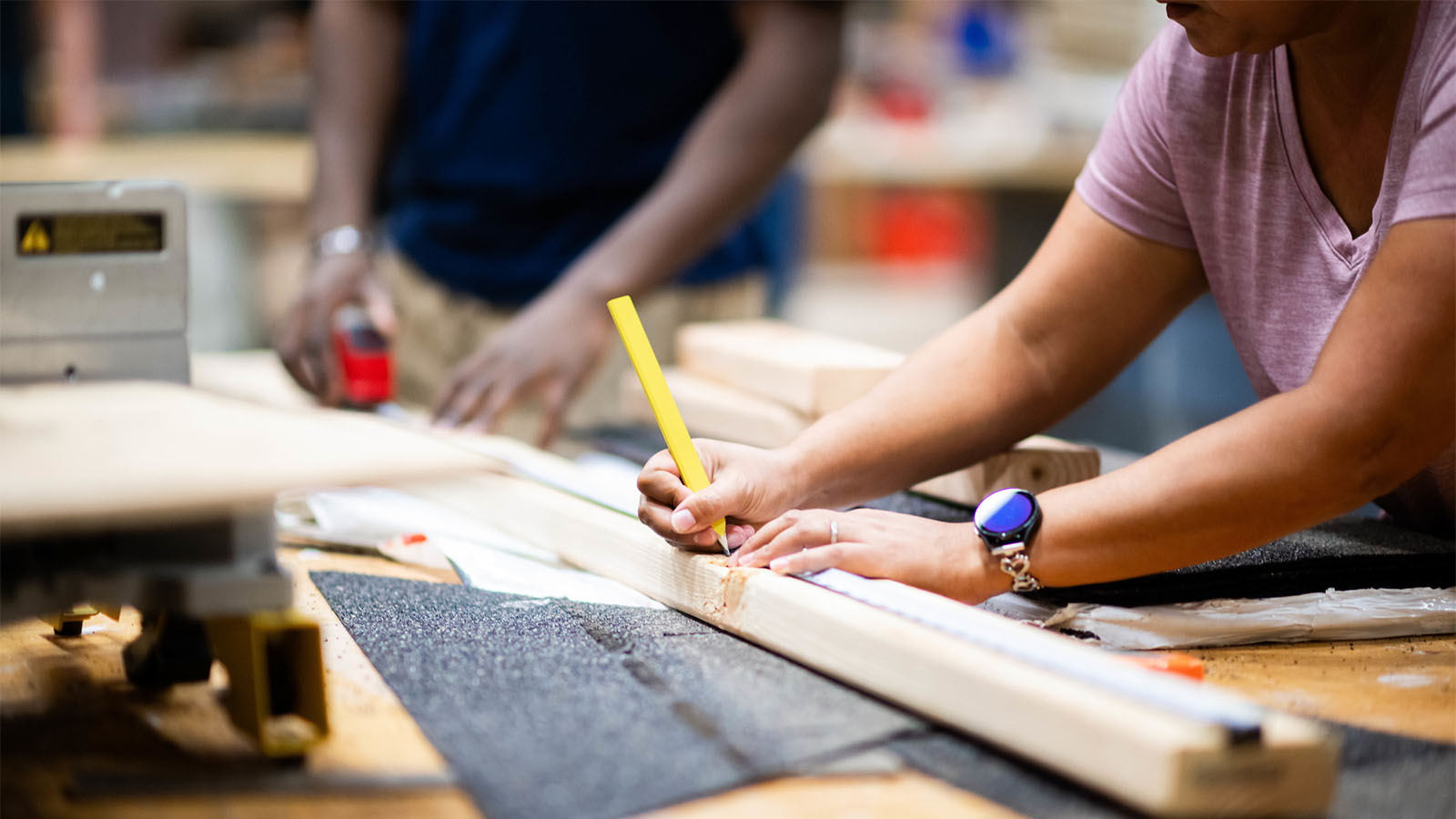 Students make measurement for wood work.