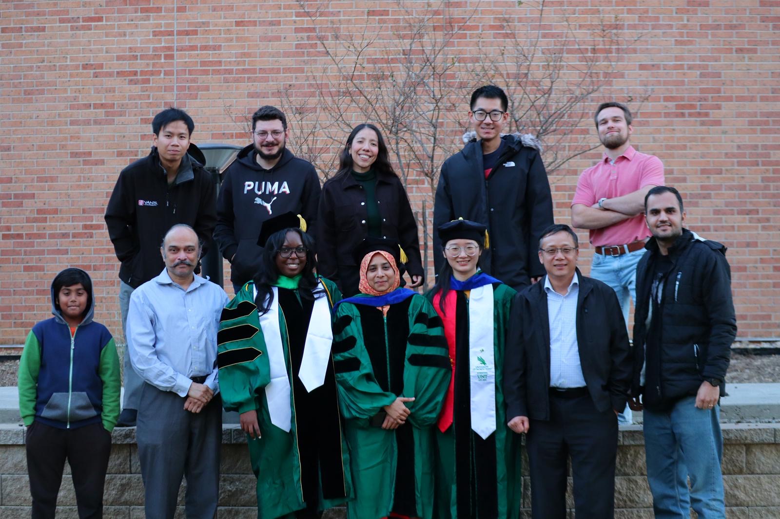 Dr. Jincheng Du with students outside the building
