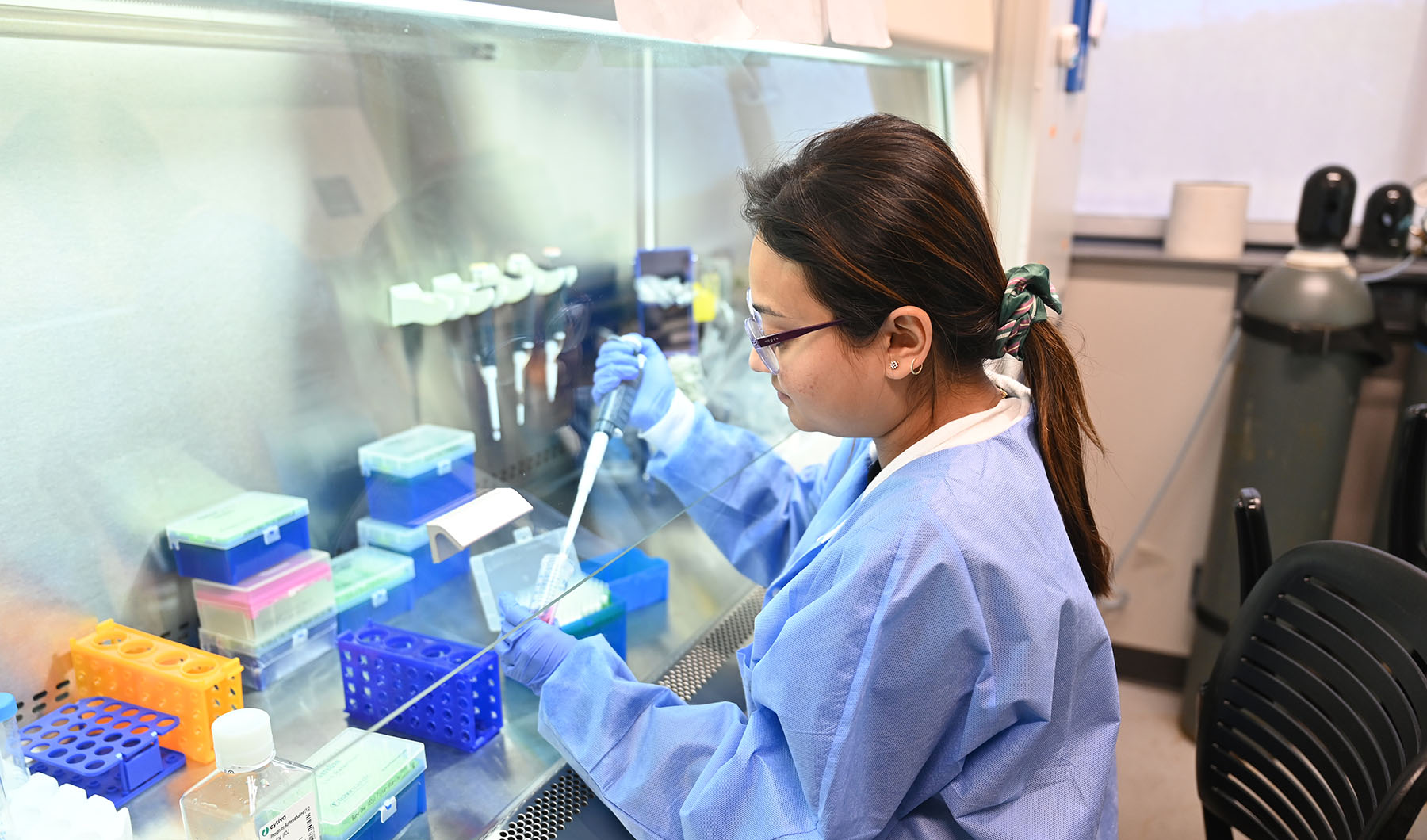 A female student in lab coat working in lab