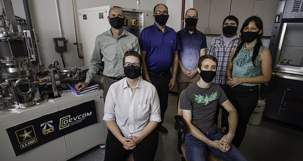 Three faculty members with students in lab