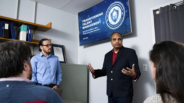 UNT faculty Ram Dantu and Cihan Tunc talking to students