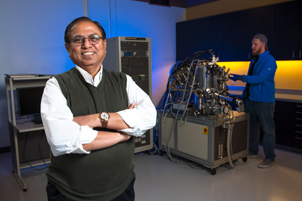 Narendra Dahotre standing in front of lab equipment