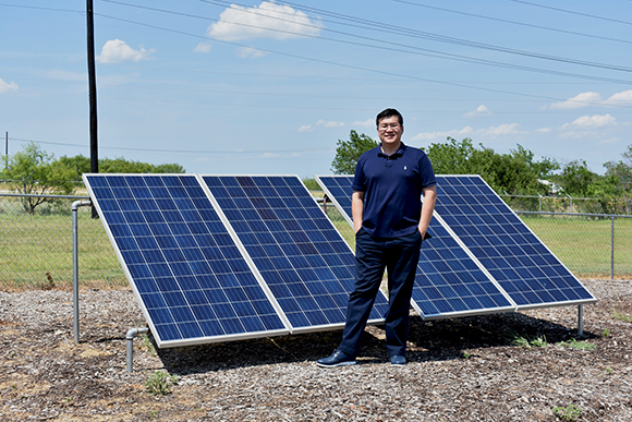 Tao Yang standing with solar panels