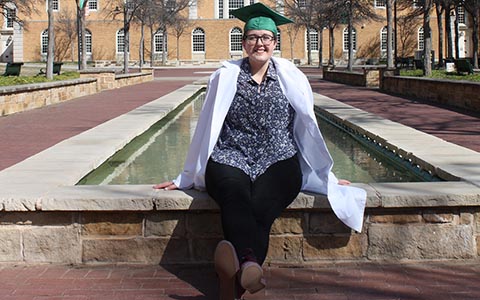 Kelly Jacques sits on the fountain ledge in front of the Hurley Administration Building.