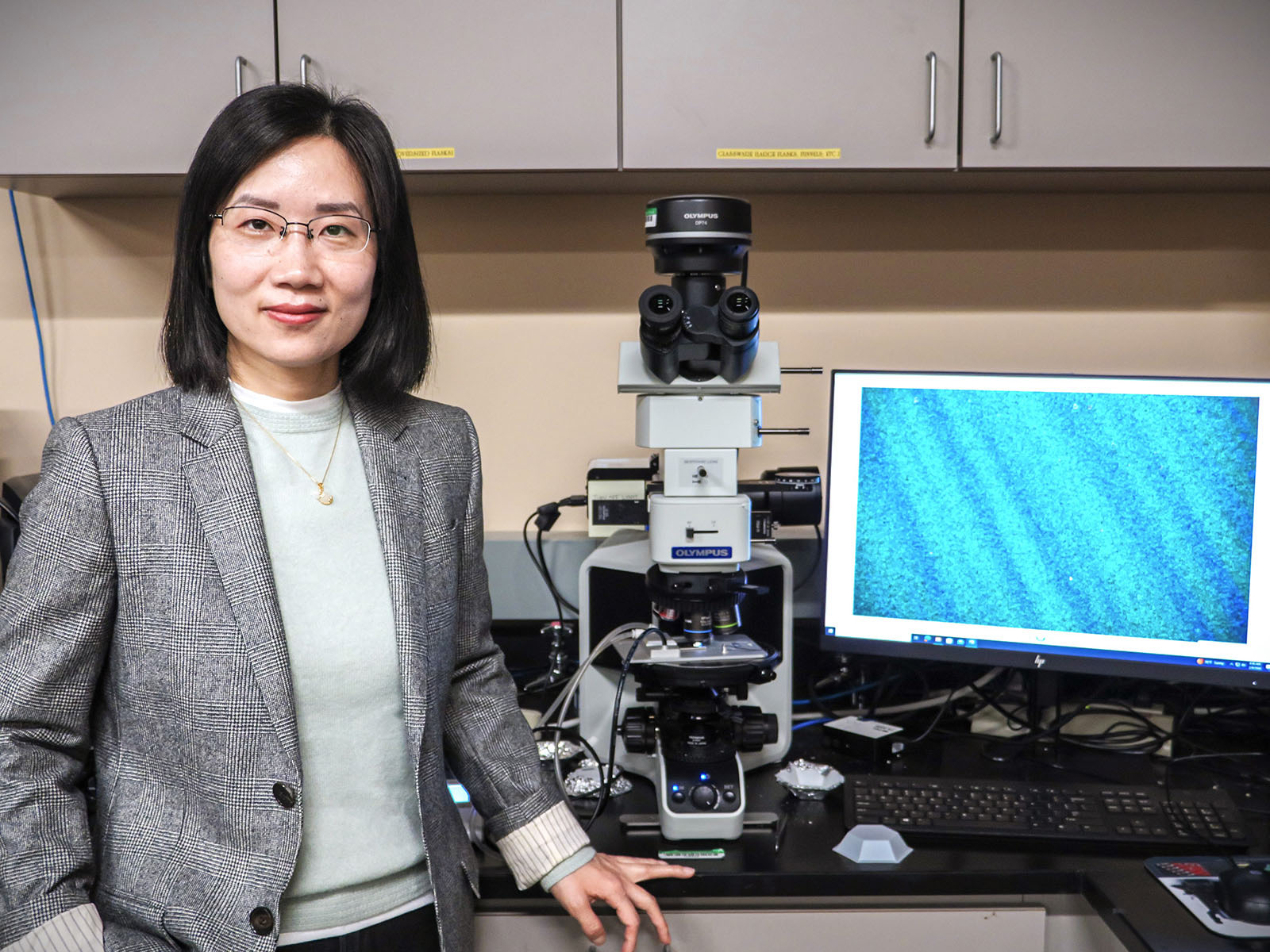 Dr. Xiao Li standing by the lab equipment
