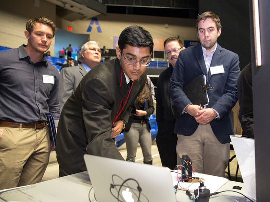 Ritik demonstrating his research on computer screen