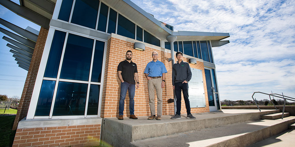 Siu and Hassan Qandil pose with collaborator in front of Zero Energy Lab