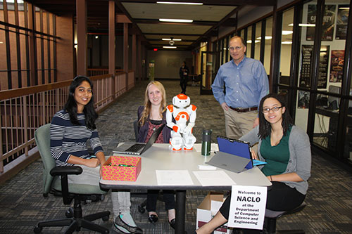 Dr. Rodney Nielsen standing with Ph.D. students Nishitha Guntakandla and Natalie Parde and undergraduate lab assistant Erin Eversoll.