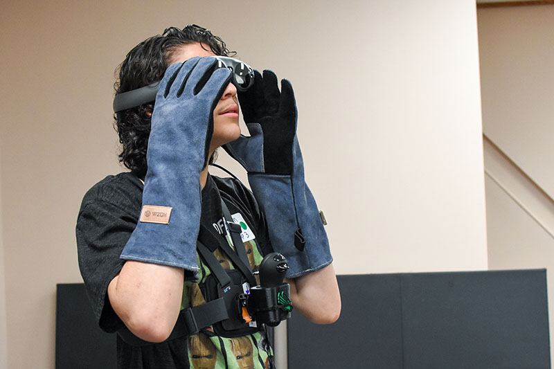 A student interacts with VR goggle.
