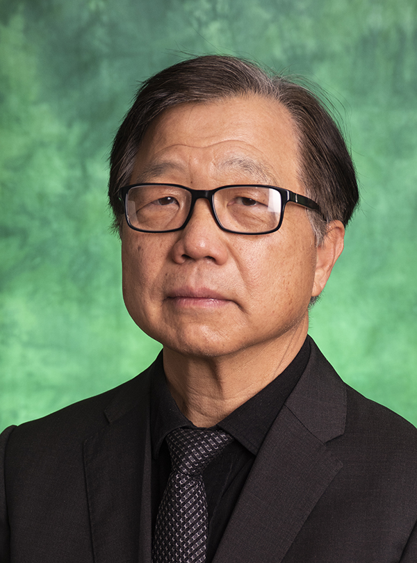 Headshot photo of Herman Shen against a green UNT backdrop