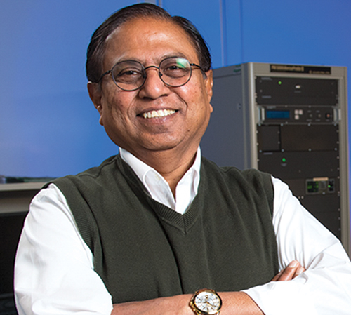 Narendra Dahotre stands in the lab smiling and with his arms crossed