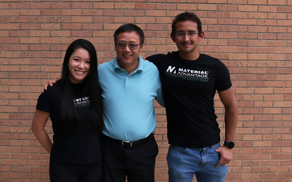 Nguyen, Du, and Gamboa pose in front of a brick wall 