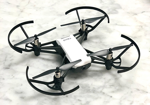 A black and white drone sits atop a marble counter.
