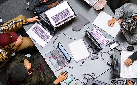 Top view of a student group working on their laptop at a table