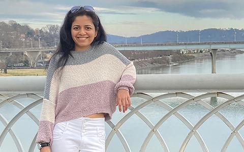 Shraddha Piparia stands on a bridge with her back against the city