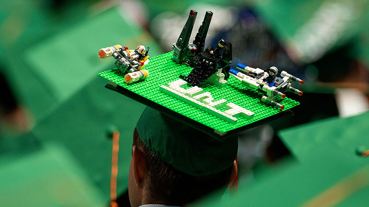 Graduate hat with lego UNT and others on top